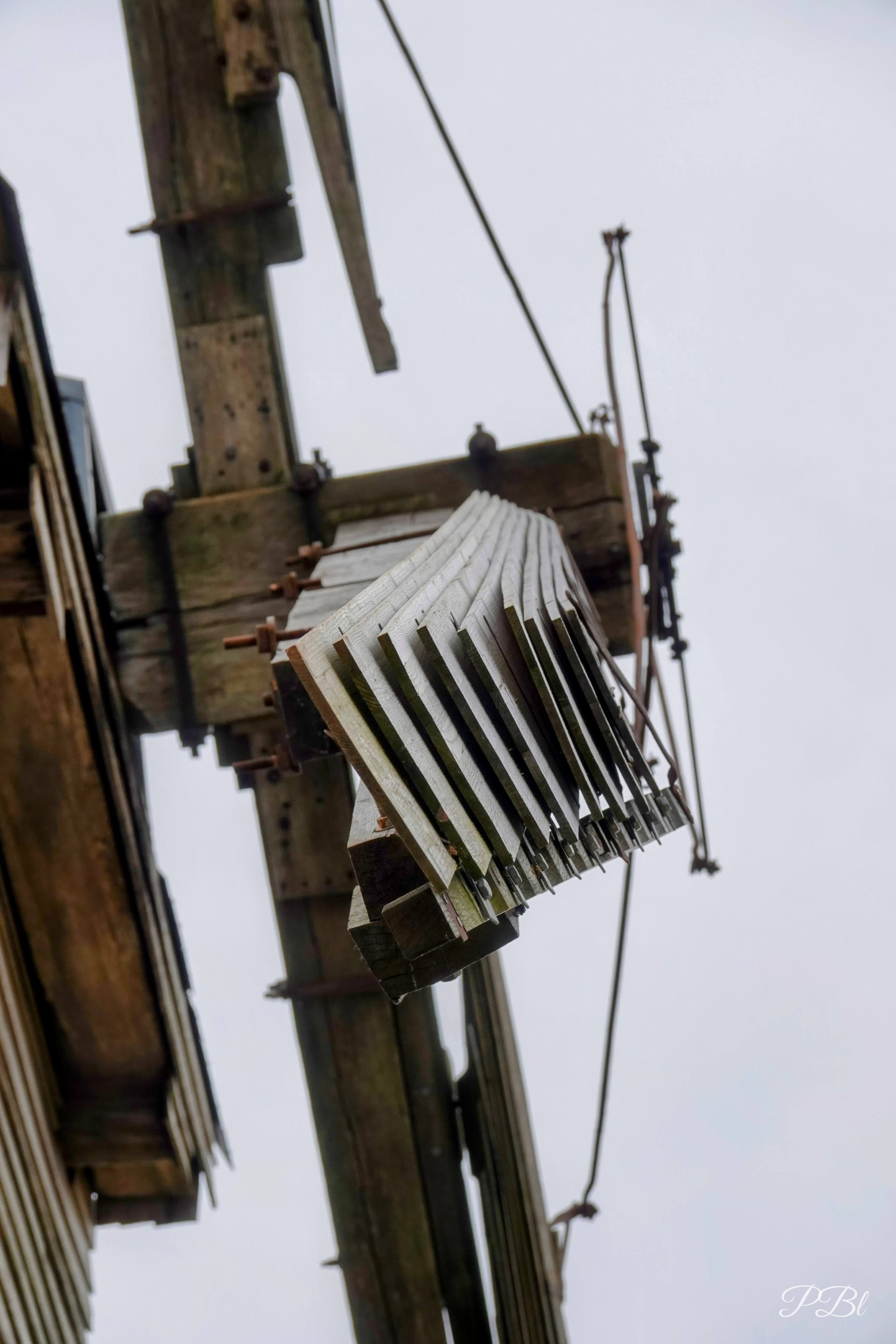Mécanisme en bois d'une aile de moulin à vent, vu d'en bas